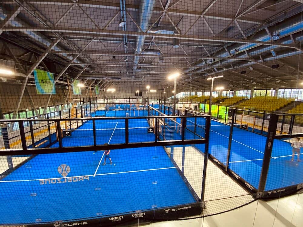 Padel Tennis Courts von schräg oben gesehen. 5 Courts in einer großen Halle.