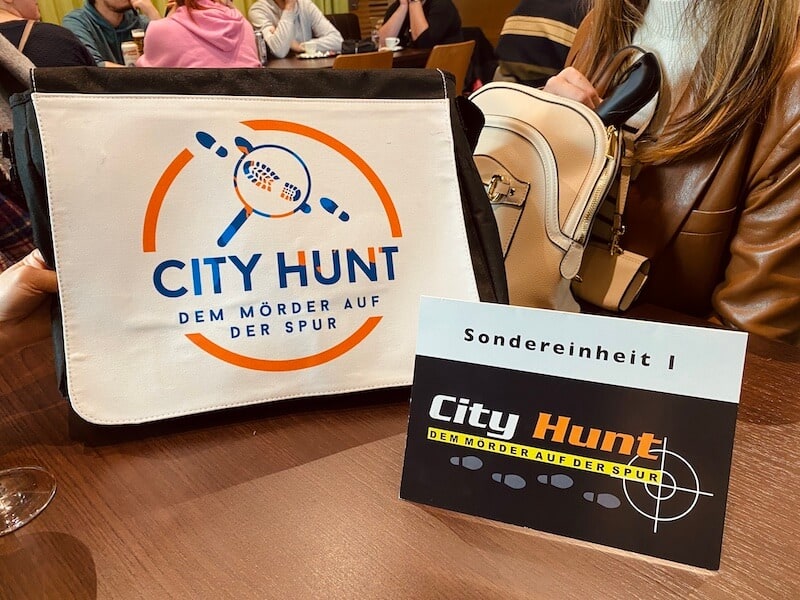 Tasche mit der Aufschrift City Hunt daneben ein Schild mit der Aufschrift Sondereinheit 1