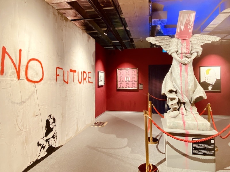 "No Future" Street Art auf der Banksy Ausstellung in Wien.  Rechts eine Skulptur.