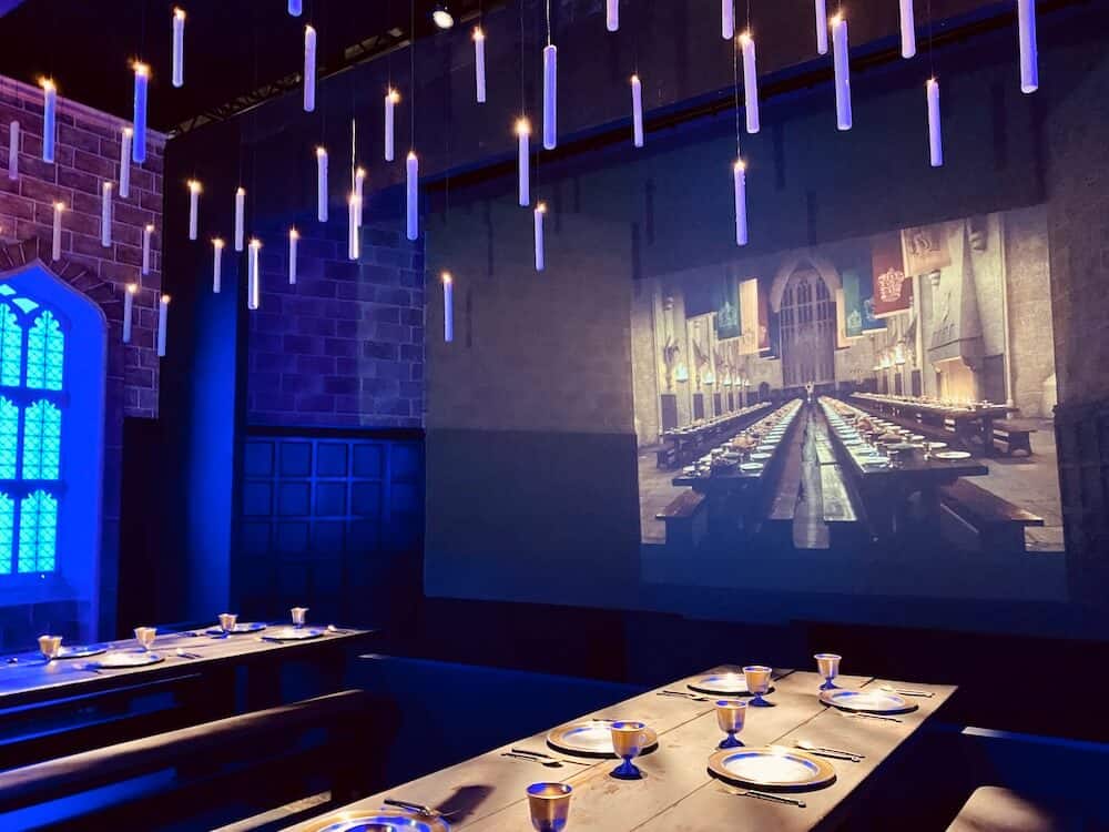 Die große Halle i der Harry Potter Ausstellung. Langer Tisch und an der Decke schwebende Kerzen