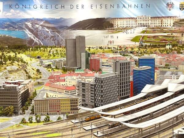 Miniatur Wien. Gebäude und Teil des Hauptbahnhofes. Schienen und Häuser im Hintergrund.