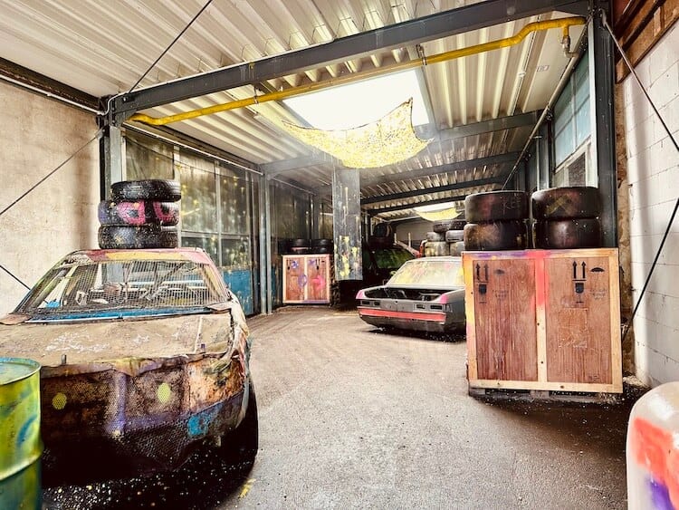 Freizeit-in-Wien-Wild-Base3 Paintball Indoor Area. Links ein altes Auto, rechts Kisten. Lagerhalle und Ambiente wie in einer verlassenen Gegend.