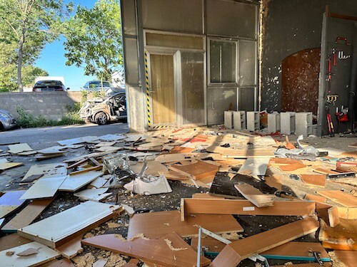 Trümmerhaufen am Boden. Lagerhalle mit Holzbrettern am Boden nach Zerstörung.